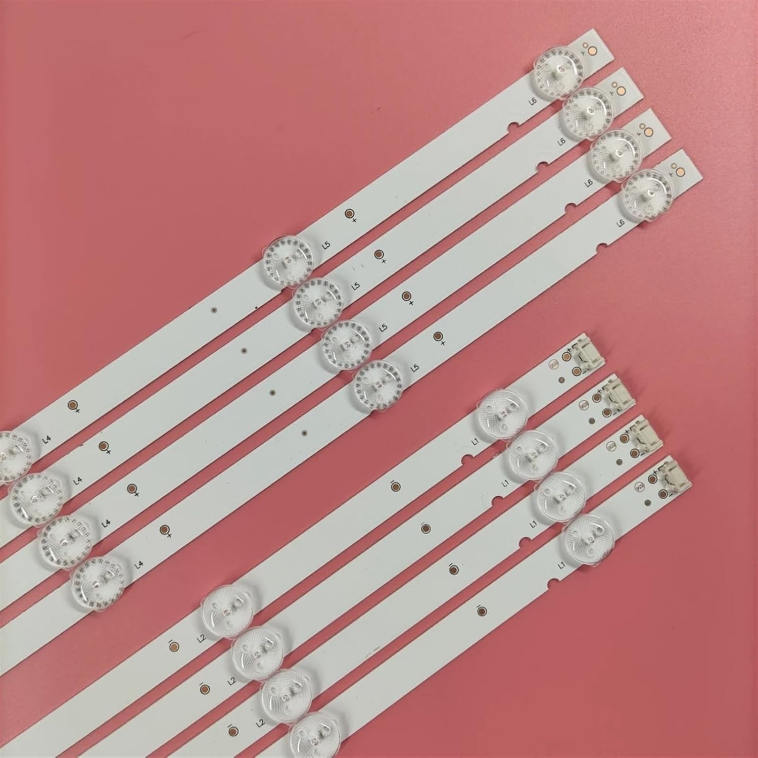Close-up of an LED backlight strip showing individual LED lenses and the electrical connector at one end.