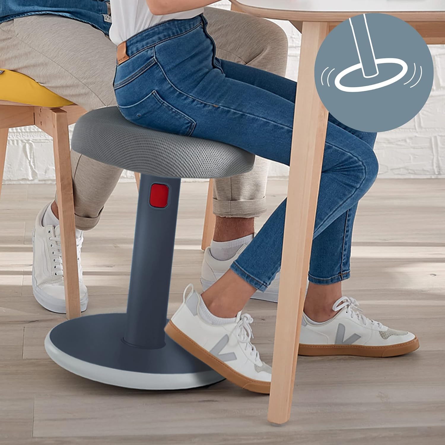 Person actively sitting on a Leitz Ergo Cosy stool at a desk, showing slight rocking motion