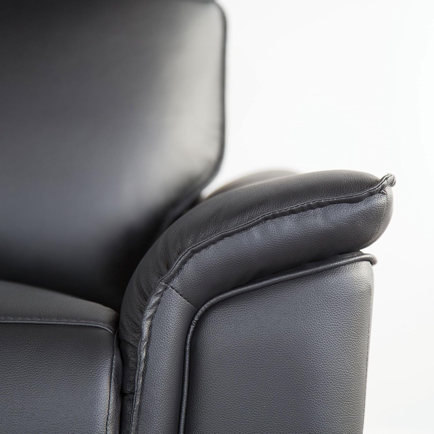 Close-up of a padded armrest on the black leather recliner