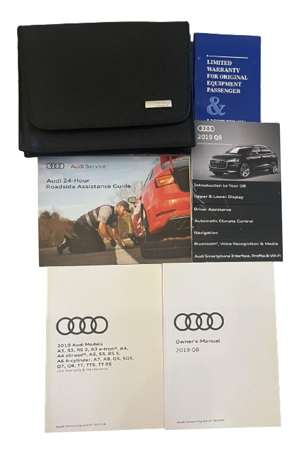 Collection of 2019 Audi Q8 owner's manual documents, including the main owner's manual, a roadside assistance guide, a warranty booklet, and a quick start guide, all neatly arranged.