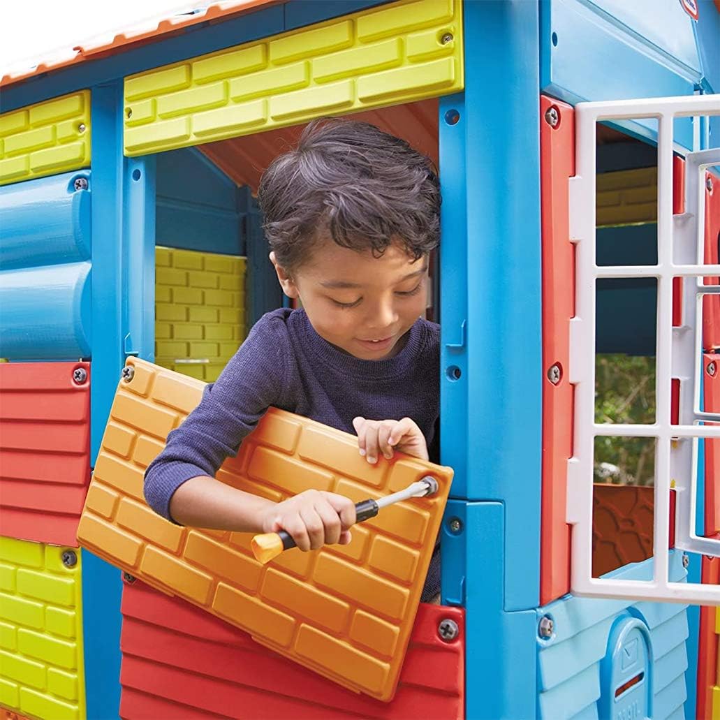 A child using the kid-friendly screwdriver to attach an orange textured panel to the playhouse frame.