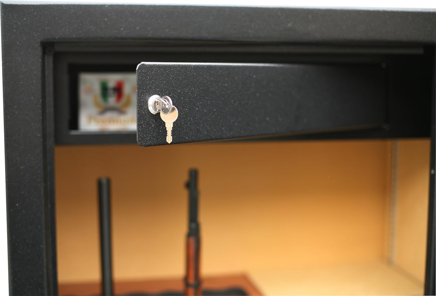 Interjeras view of the gun safe showing the top lockable compartment with a key inserted