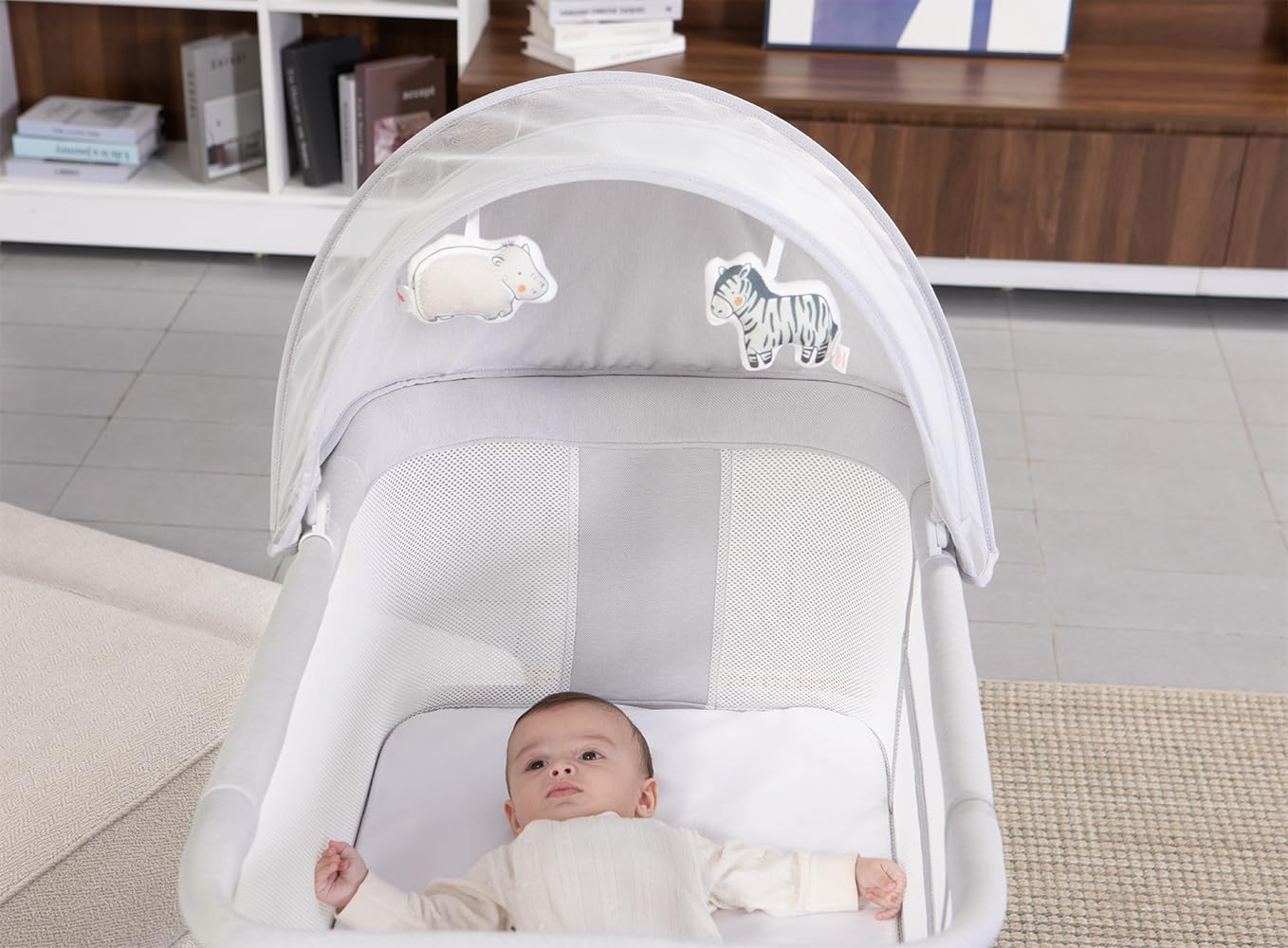 Close-up of a baby in the Mastela Motion Sensor Automatic Rocking Bassinet with the mosquito net in place.