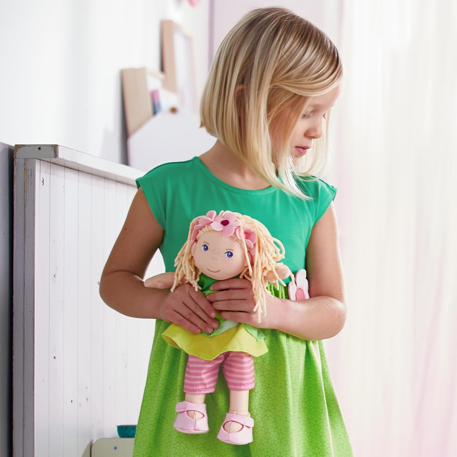 A child holding the Mali doll, illustrating its suitable size for young children.