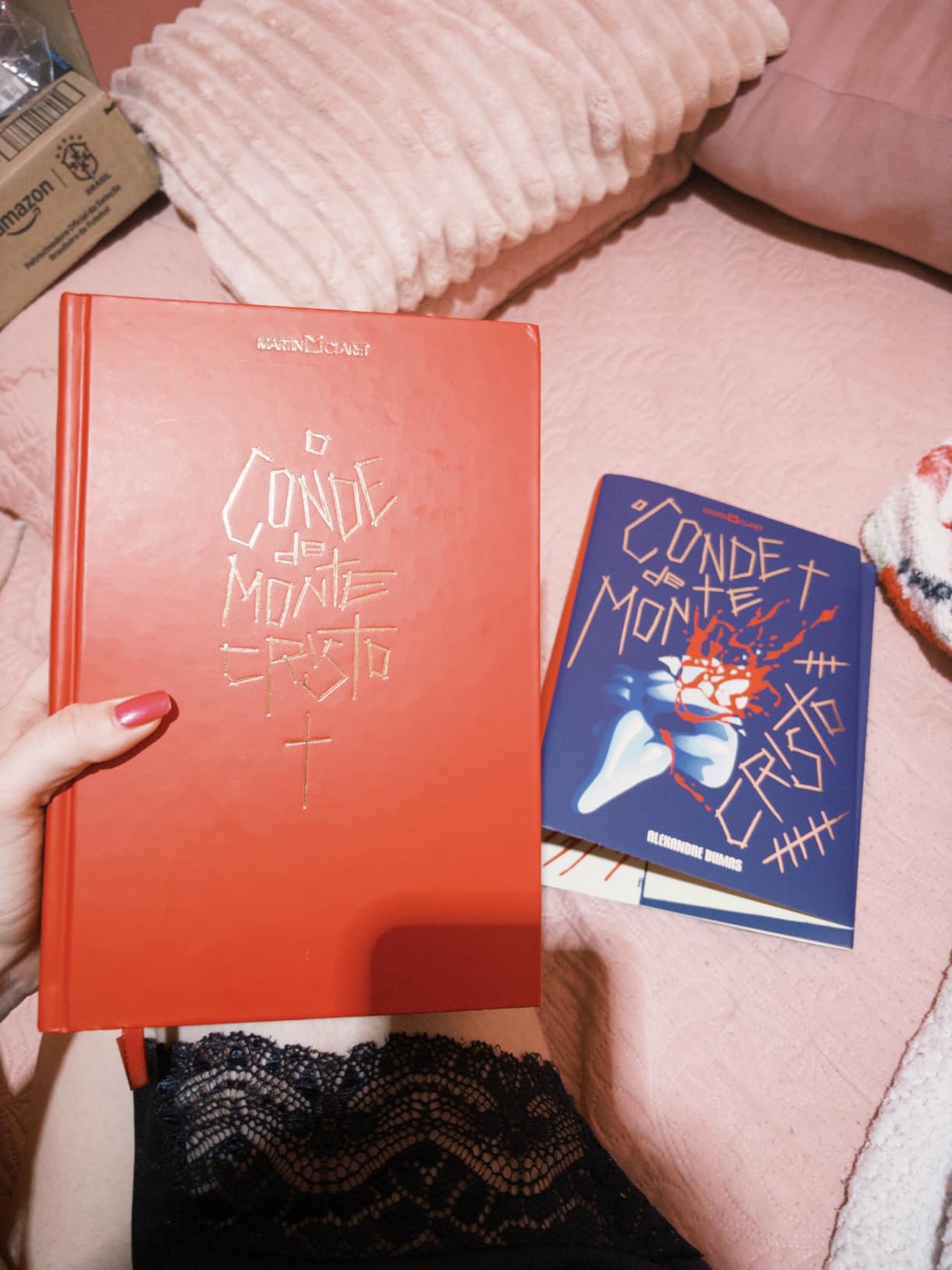 Duas versões do livro O Conde de Monte-Cristo sendo uma com capa vermelha e outra com capa azul