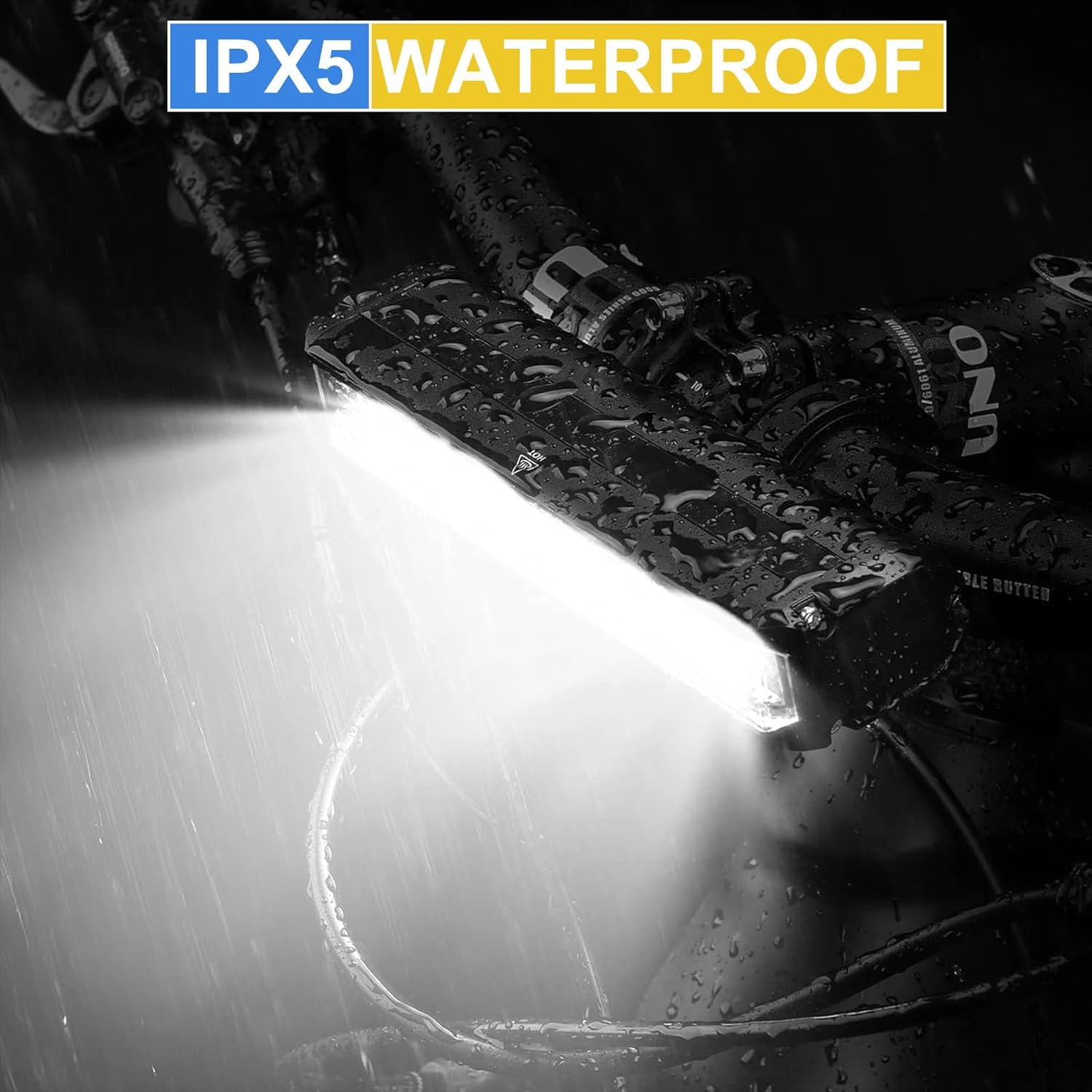 Minsk W605 bike light on a handlebar with water droplets, demonstrating IPX5 waterproof rating