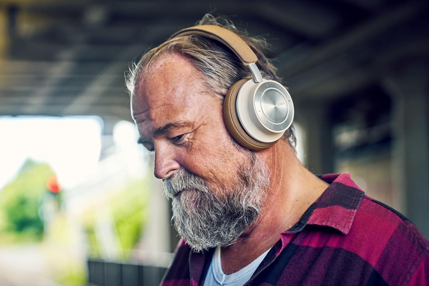 Person wearing DALI IO-8 headphones in an outdoor setting