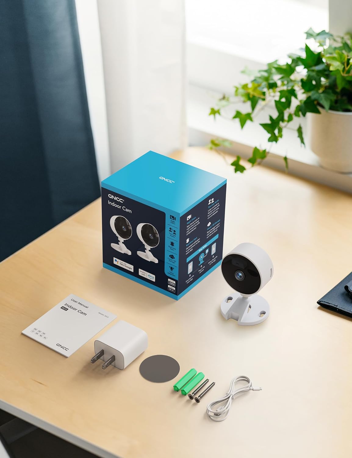 Contents of the GNCC Indoor Camera box, including the camera, power adapter, instruction manual, mounting screw, and power cord.