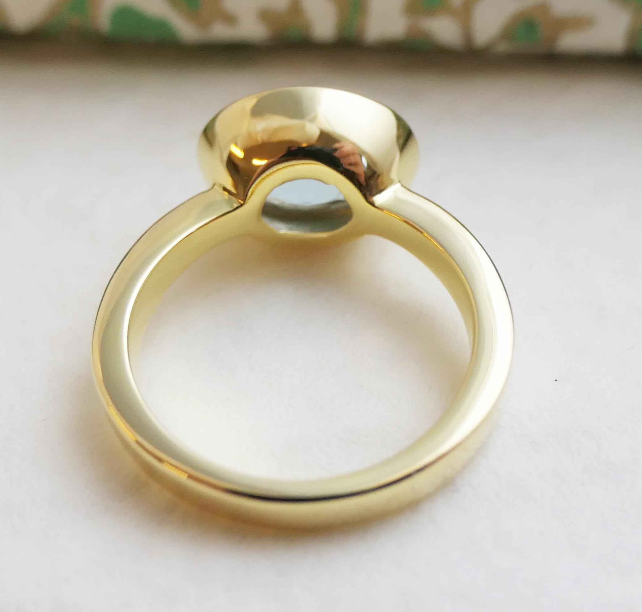 Anillo ovalado de plata de ley con baño de oro y topacio azul