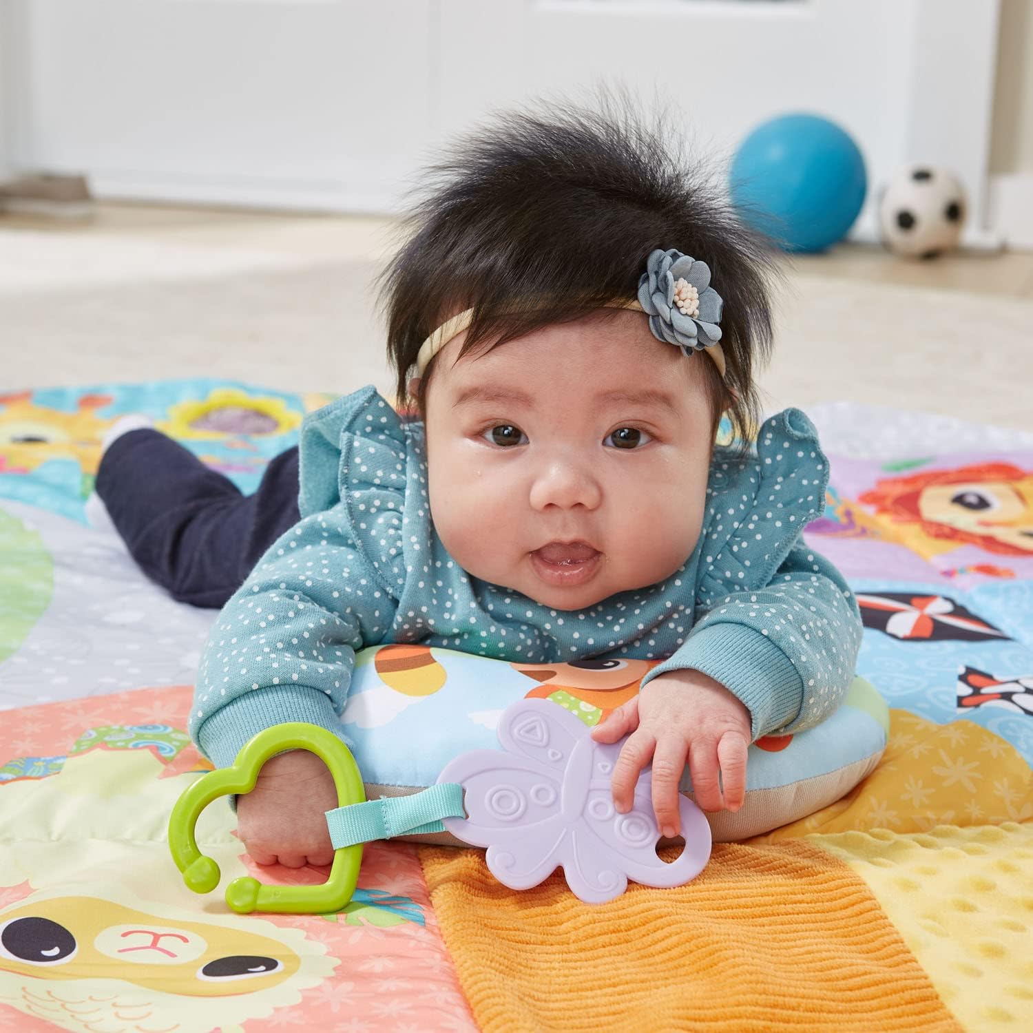 Baby on tummy time on the VTech 7-in-1 Senses and Stages Developmental Gym, interacting with the xylophone