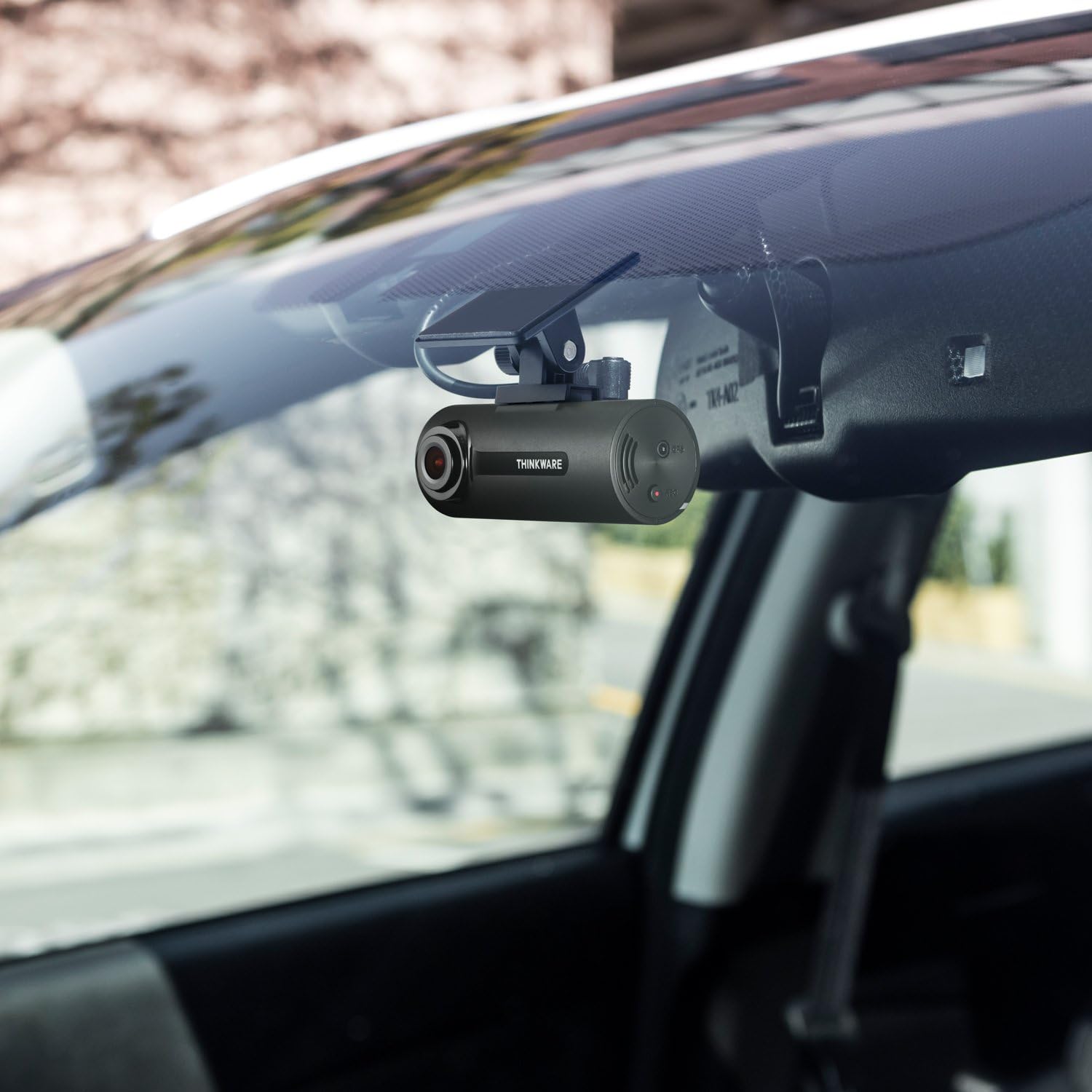 THINKWARE F70 Dash Cam installed on a car windshield, viewed from inside the vehicle.