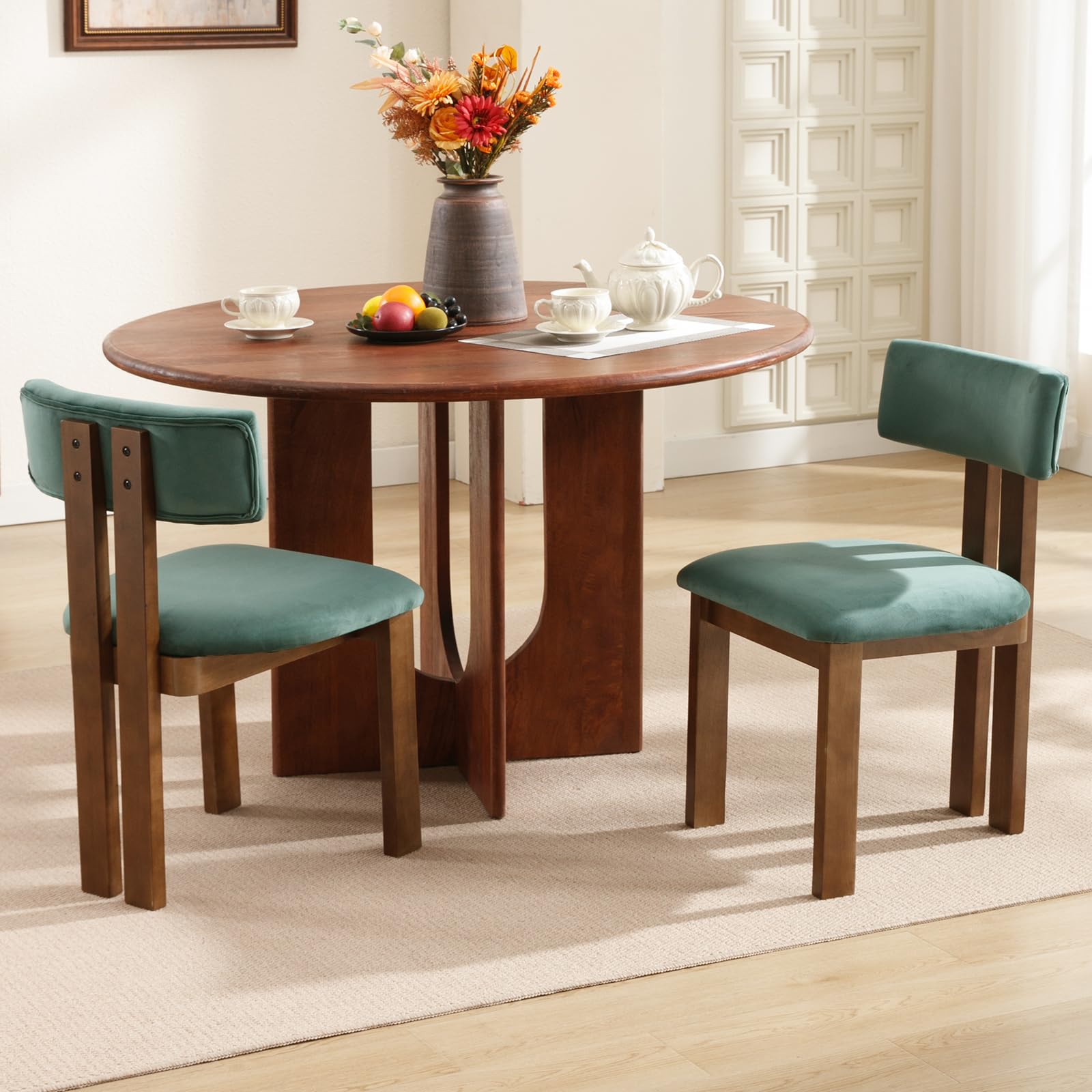 Mesa de comedor redonda de madera y sillas de terciopelo verde