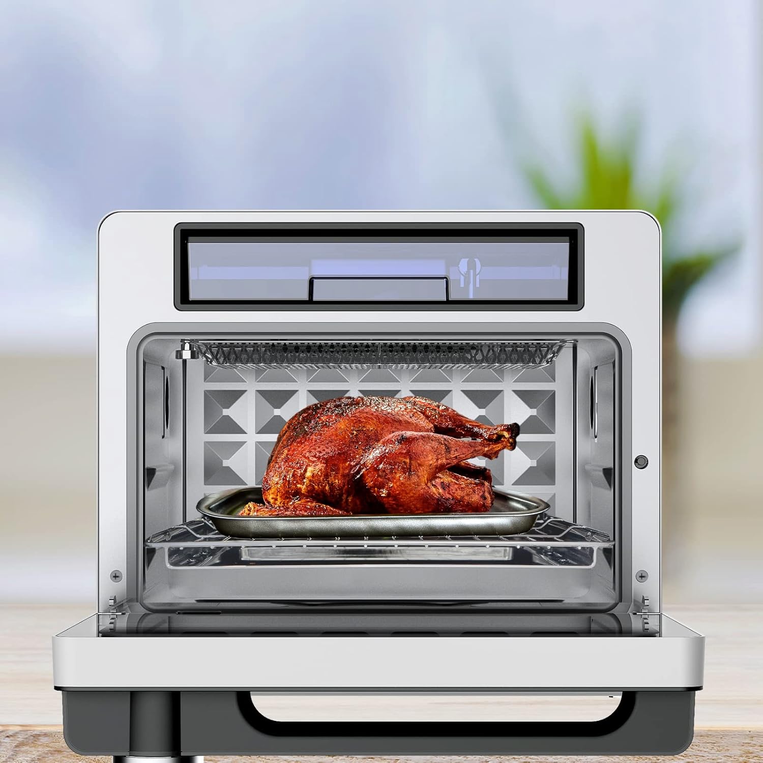A whole roasted chicken inside the Kitchen Couture Air Fryer, placed on a wire rack.