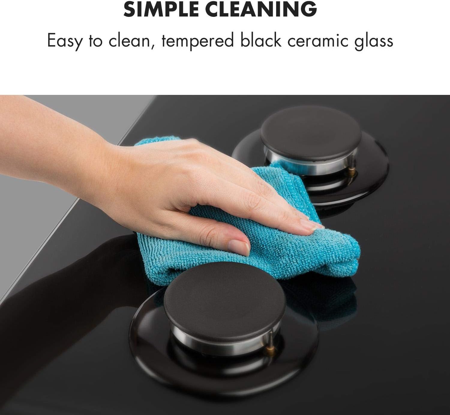 A hand cleaning the black ceramic glass surface of the Klarstein Ignito Domino Gas Hob with a blue microfiber cloth.