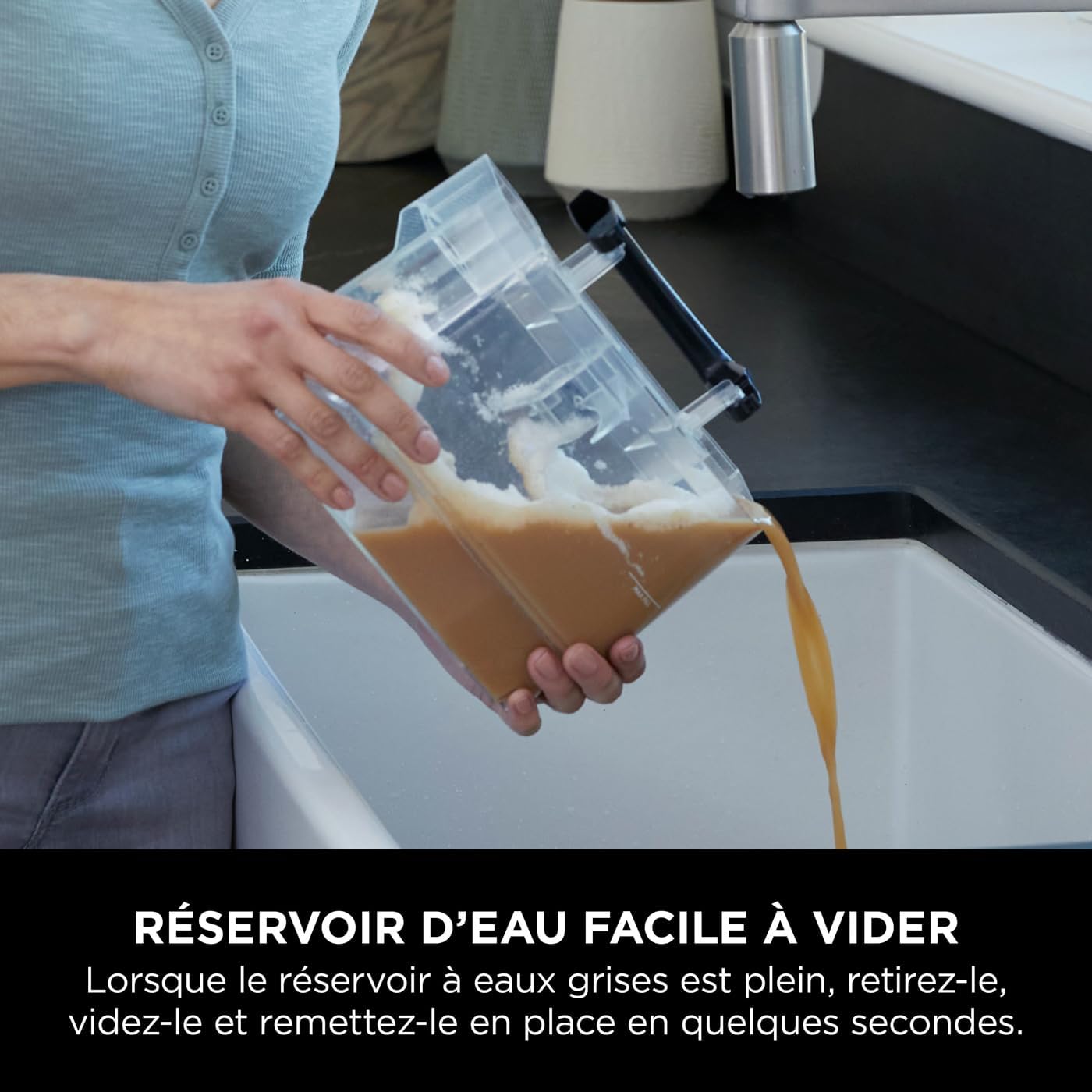 Person emptying the dirty water tank into a sink