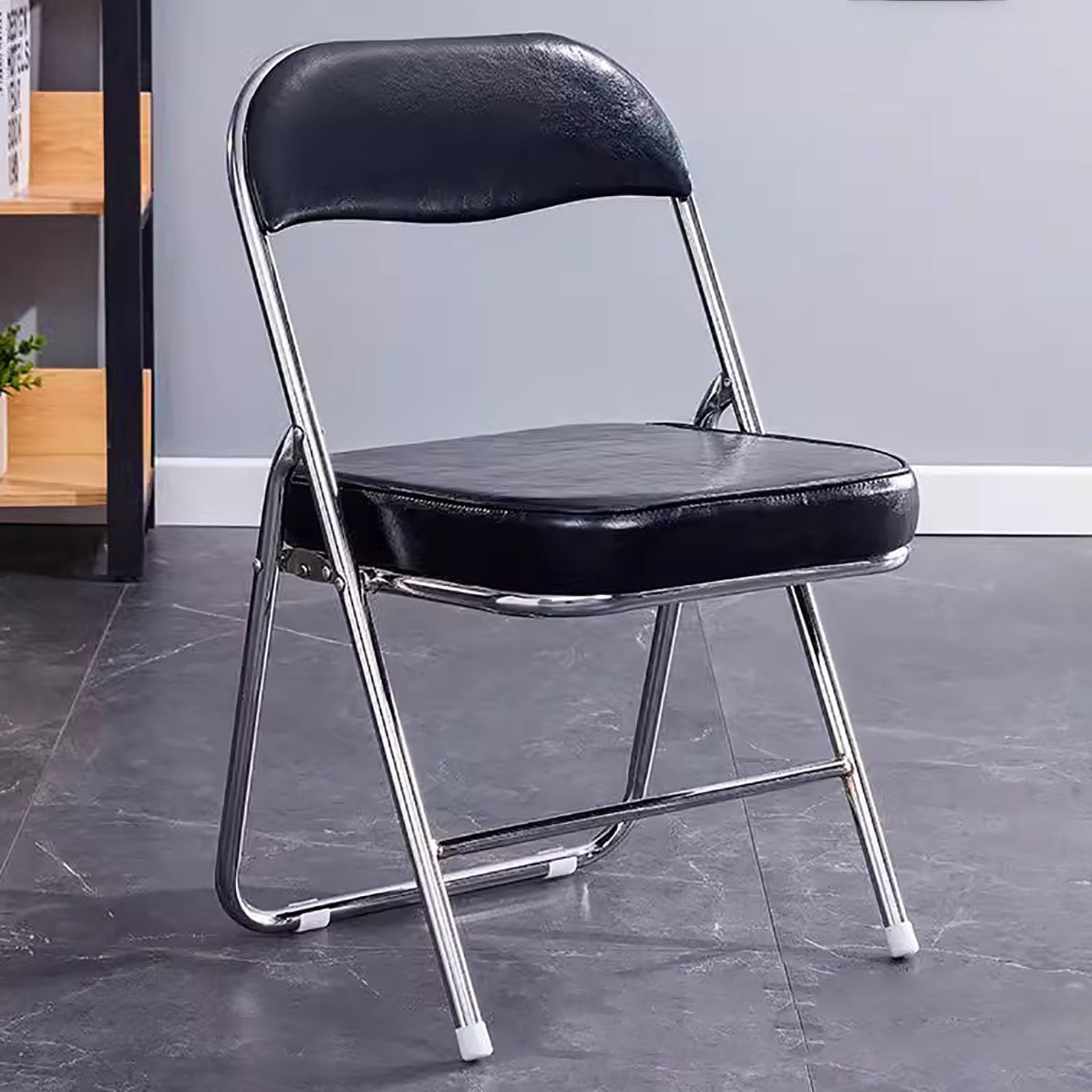 Chaise pliante en cuir rembourrée et ergonomique : assise large noire pour optimiser l'espace