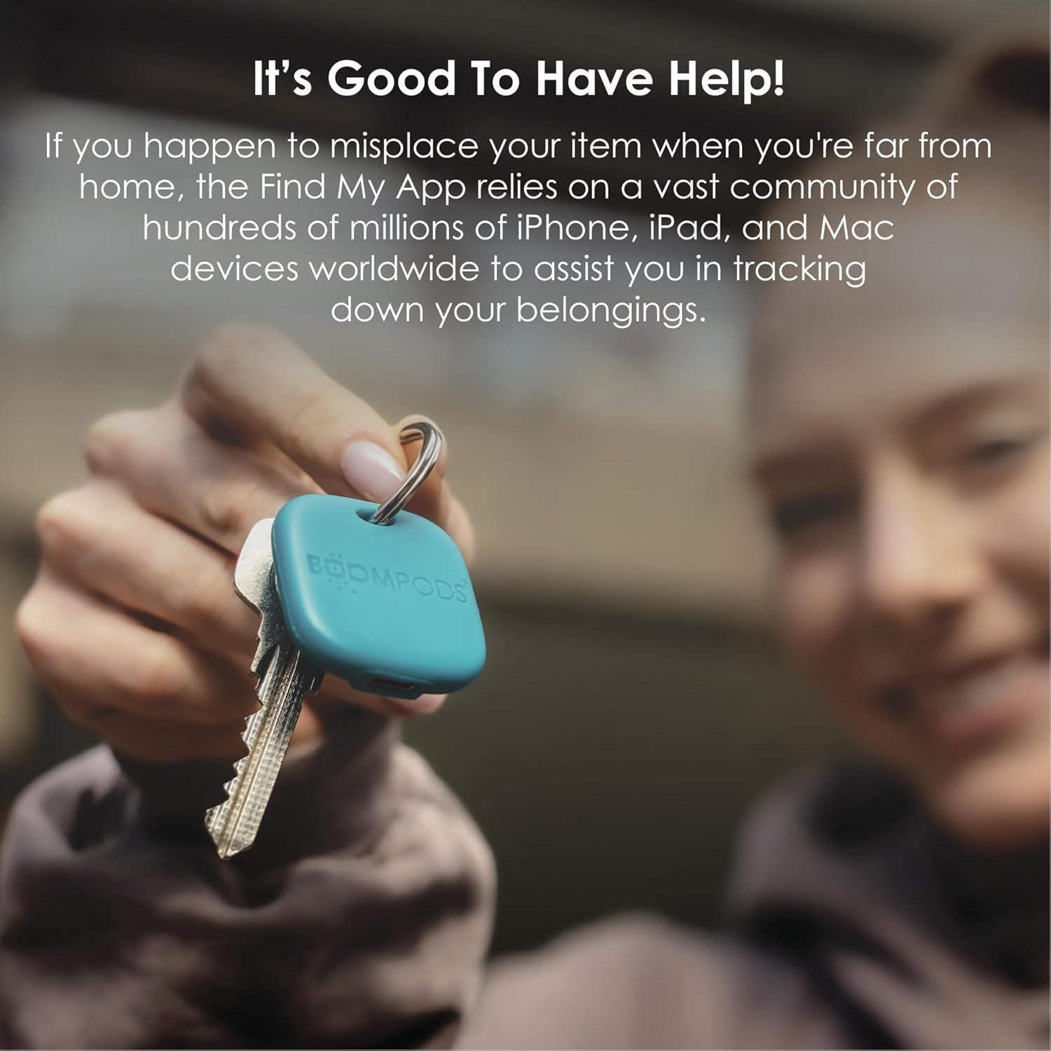 Hand holding a blue Boompods Boomtag attached to keys