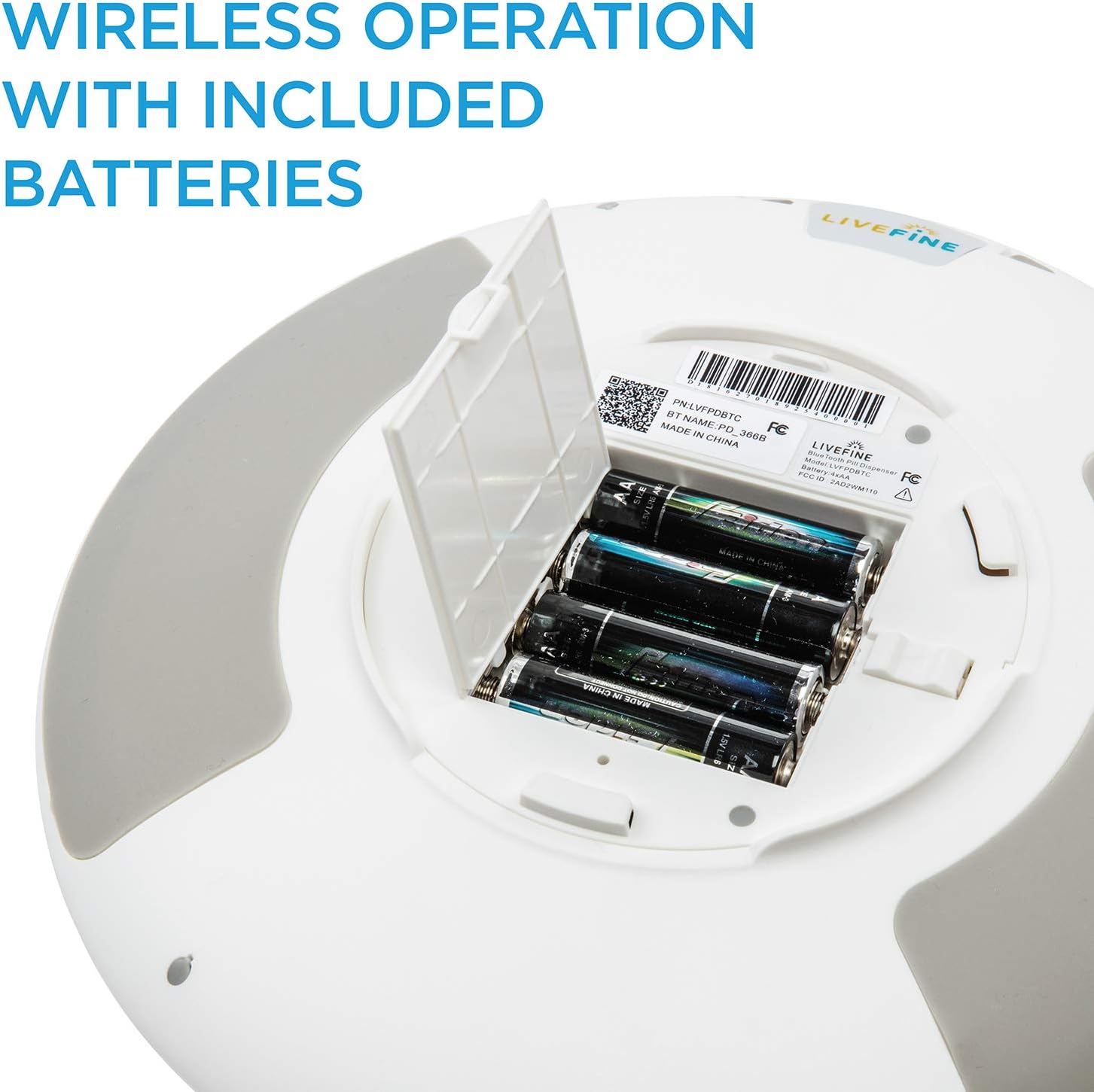 Underside of the Live Fine Automatic Pill Dispenser showing the open battery compartment with four AA batteries inserted.
