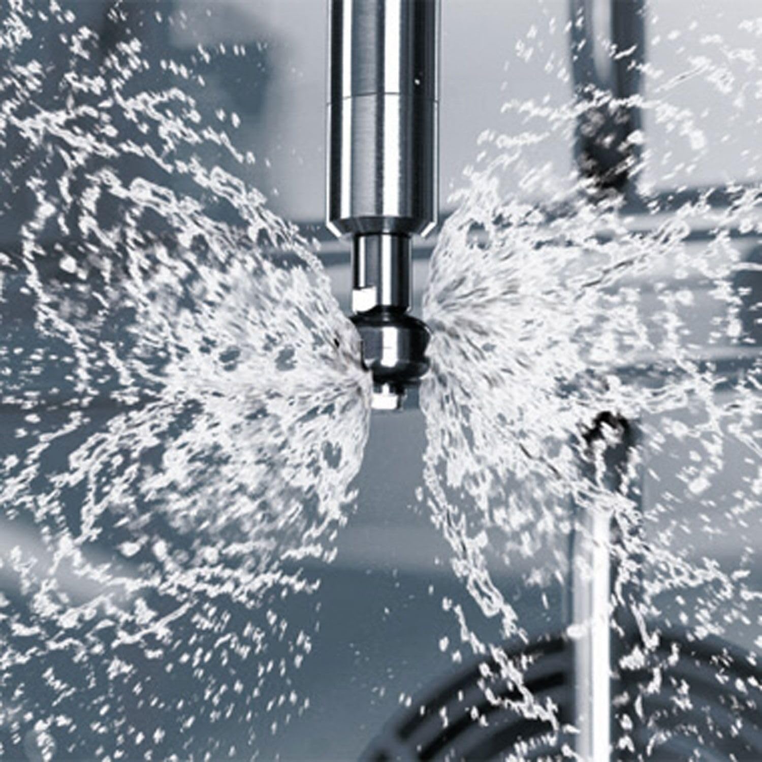 A close-up shot of water being sprayed from a nozzle inside the combisteamer, illustrating the direct steam injection system.