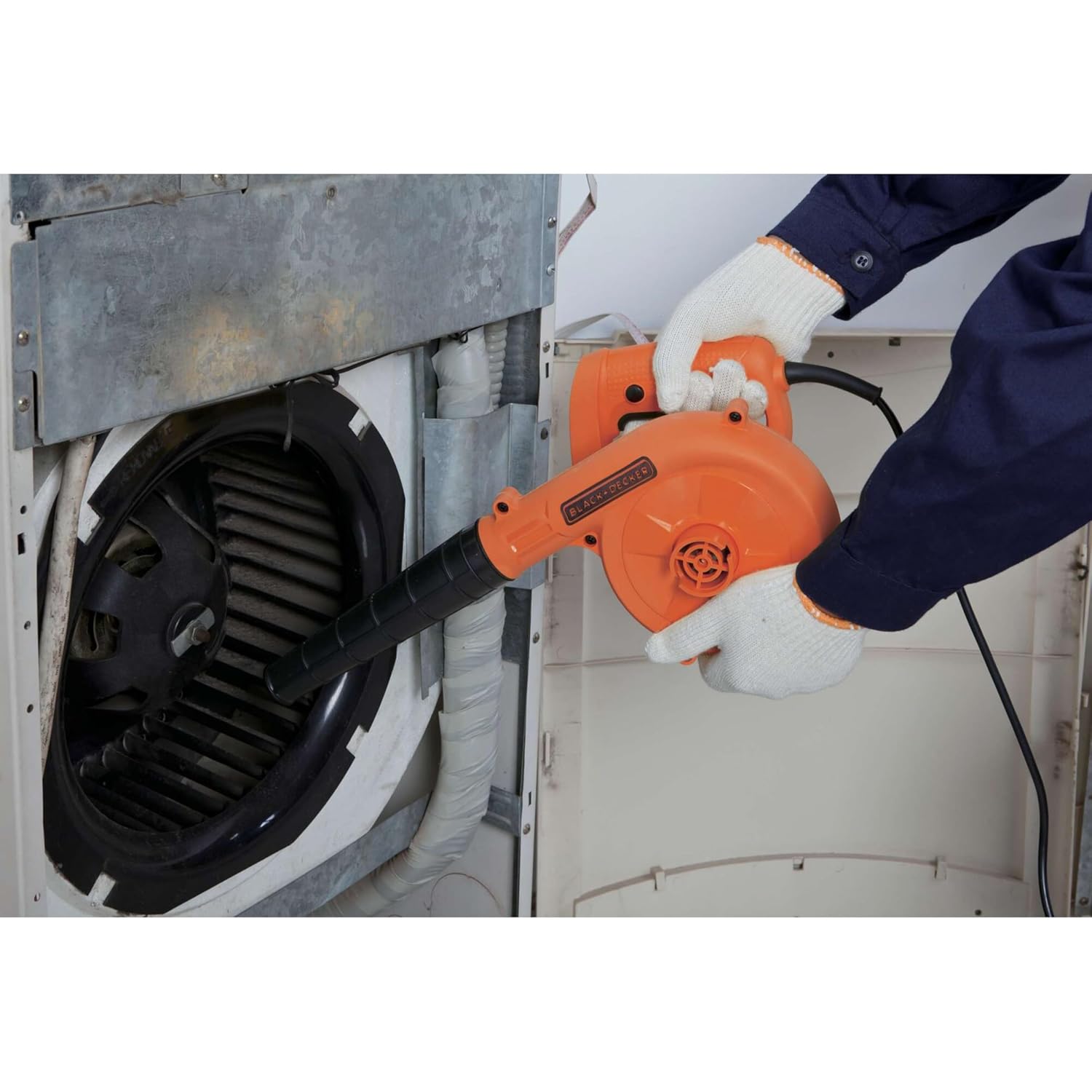 User operating the blower to clean an air conditioning unit