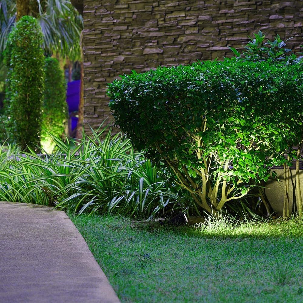 HOFTRONIC Spikey LED Garden Spike Light illuminating a green bush and plants in a garden.