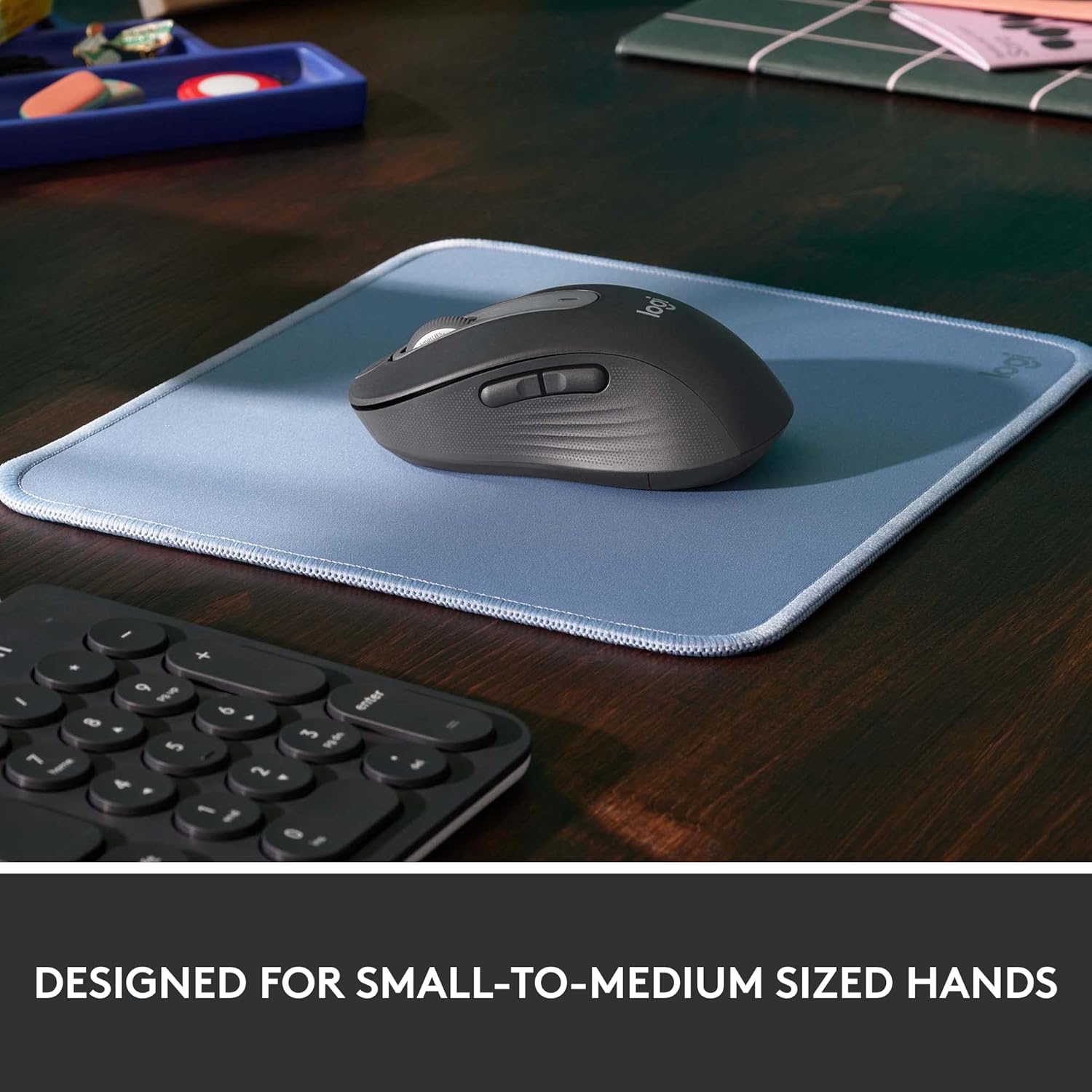 Logitech M650 mouse on a light blue mousepad, demonstrating its ergonomic design for small to medium hands