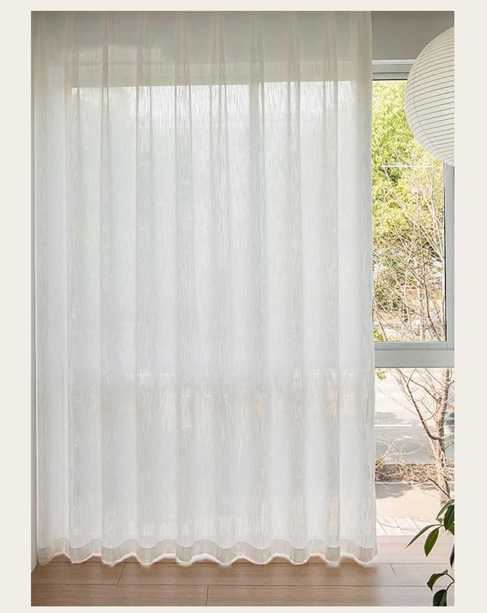 Rideau semi transparent oeillets Beydodo tamisant la lumière pour préserver l'intimité du salon