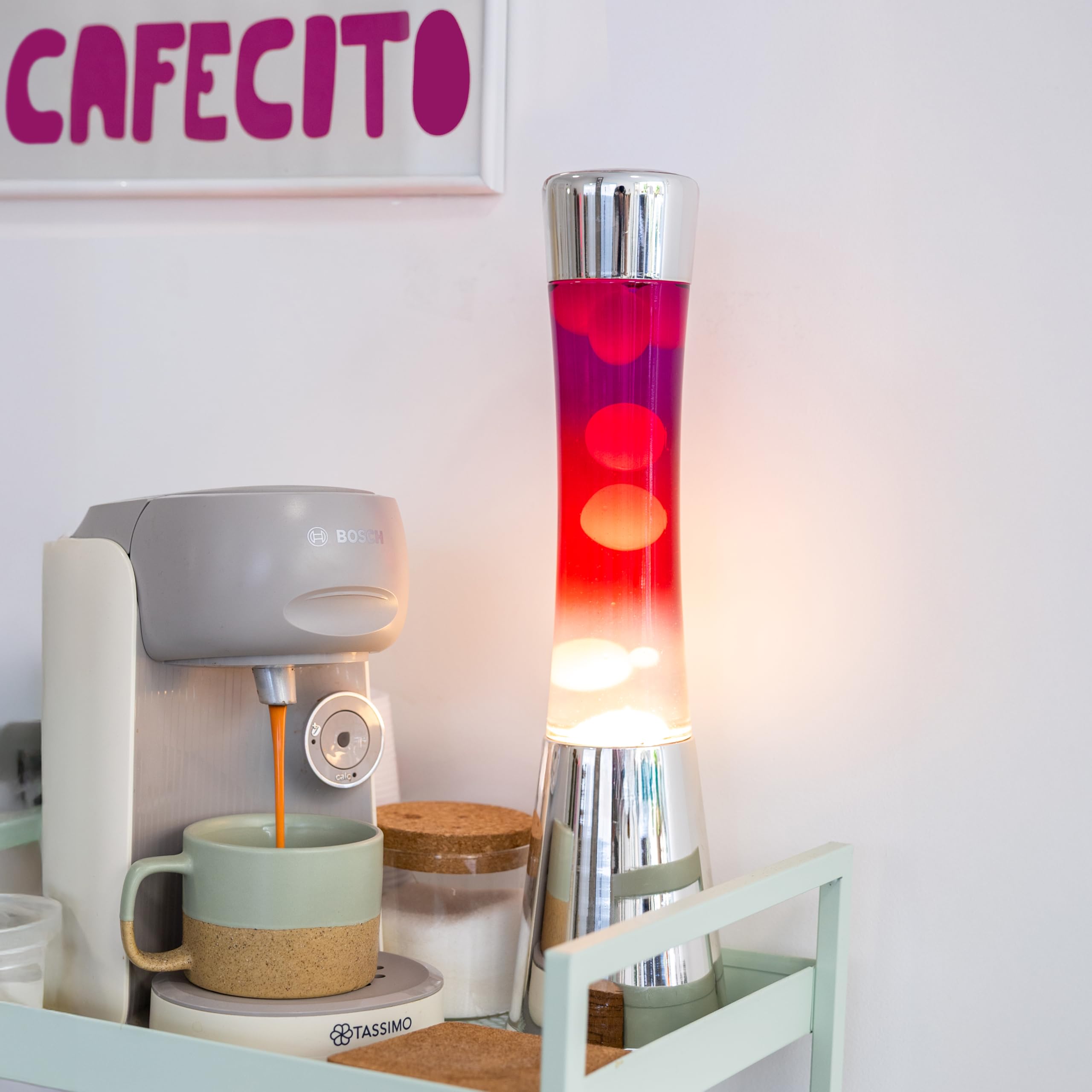 Fisura – Lampa z lawą „gradient czerwony”. Podstawa chromowana, butelka z efektem przejścia od fioletowego do białego. Lampa relaksacyjna z zapasową żarówką. 11 cm x 11 cm x 39,5 cm.