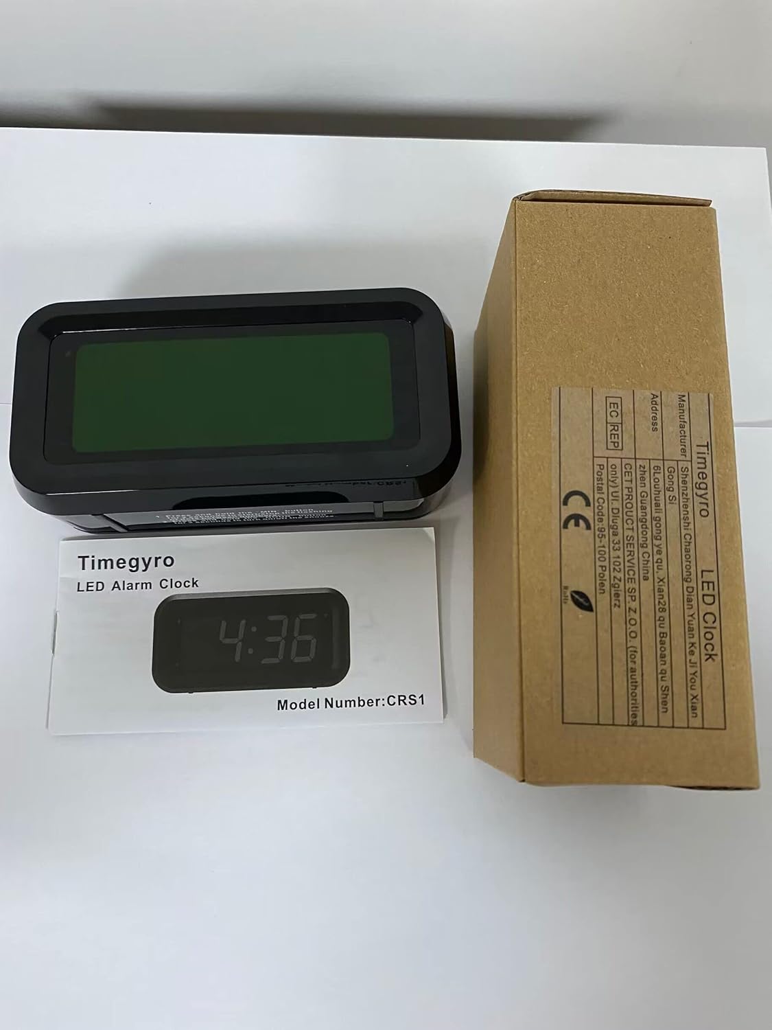 A hand pressing the snooze button on top of the Timegyro Alarm Clock, which is displaying 7:00