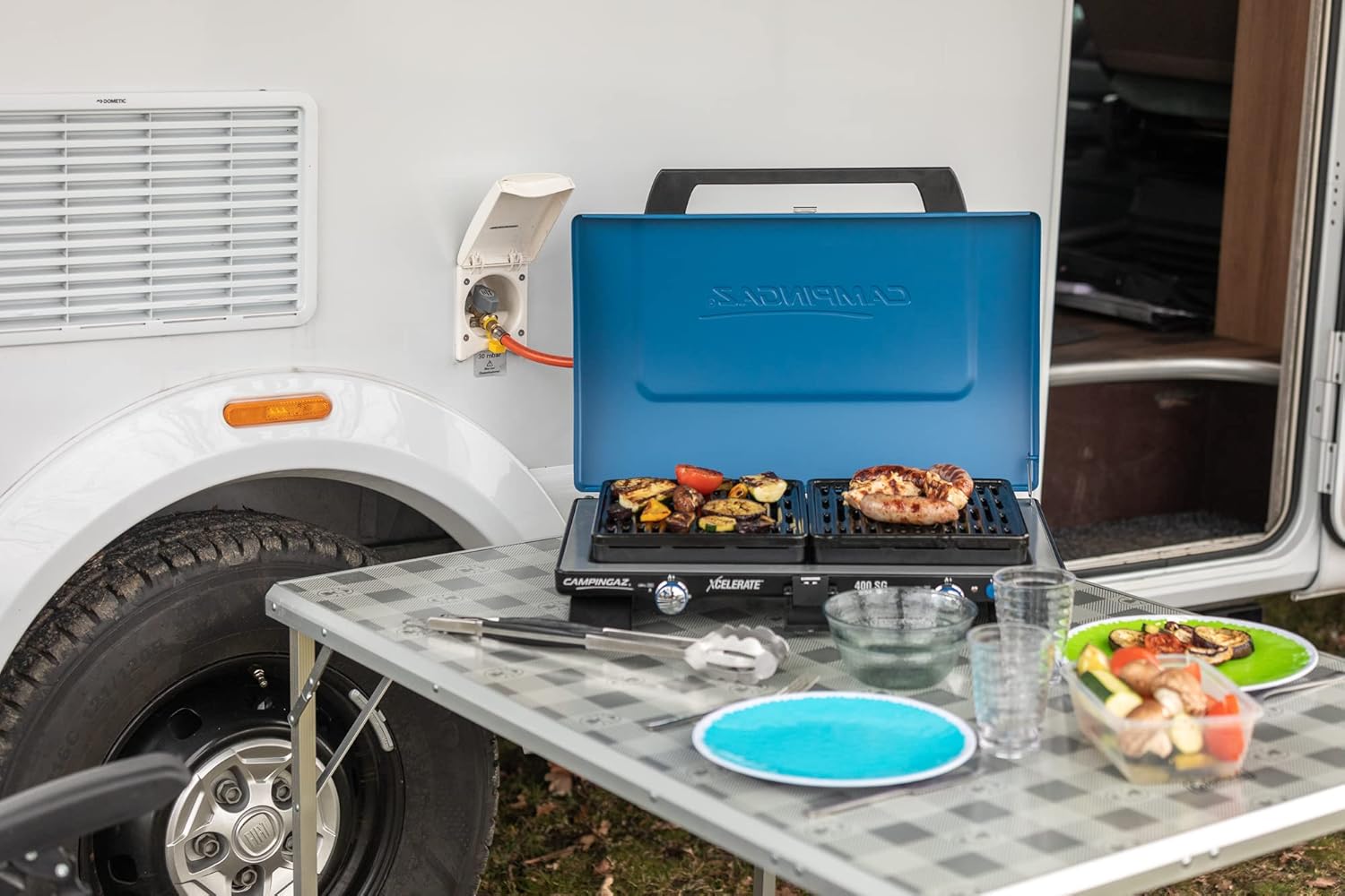 Campingaz Uni 400 SG Camping Stove in use outdoors, cooking food on both grill plates.
