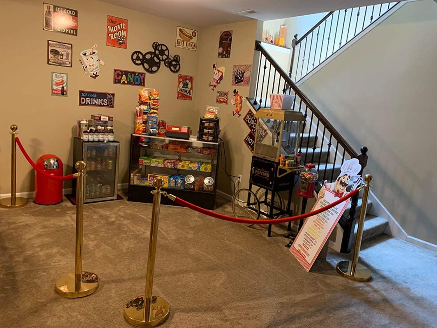 The Duck Hunt tin sign displayed on a wall in a home entertainment or movie-themed area, surrounded by other vintage-style signs and decor, including a popcorn machine and candy display.