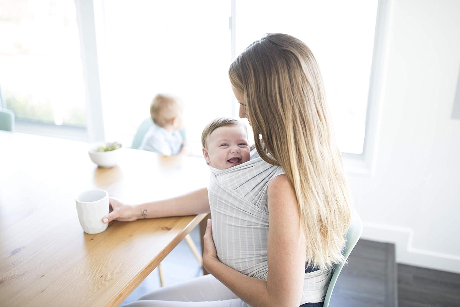 Mom with baby in Ergobaby Aura Wrap at a table