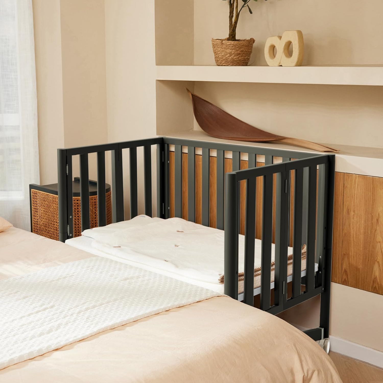 EvoNook Mini Crib positioned next to an adult bed, demonstrating its co-sleeper functionality.