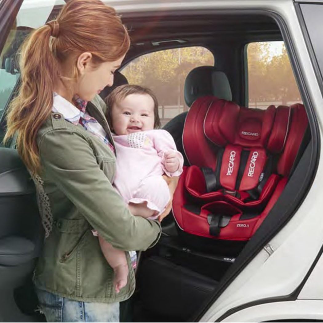 A person installing the Recaro Zero.1 Select child car seat into a vehicle's back seat.