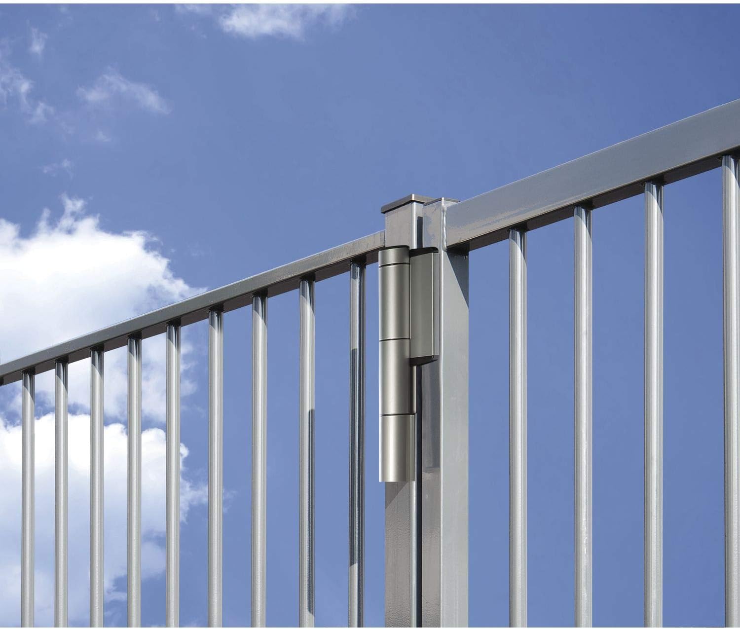 Locinox Mammoth gate hinge installed on a silver gate against a blue sky.