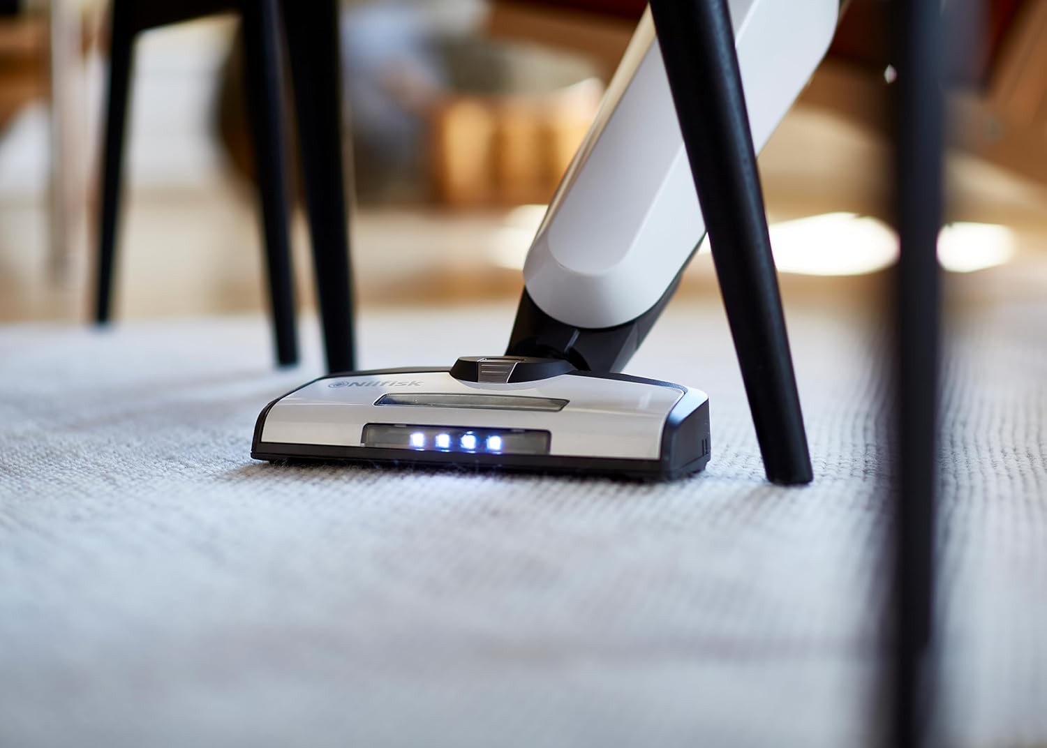 Nilfisk Easy stick vacuum cleaning a carpet with LED lights on