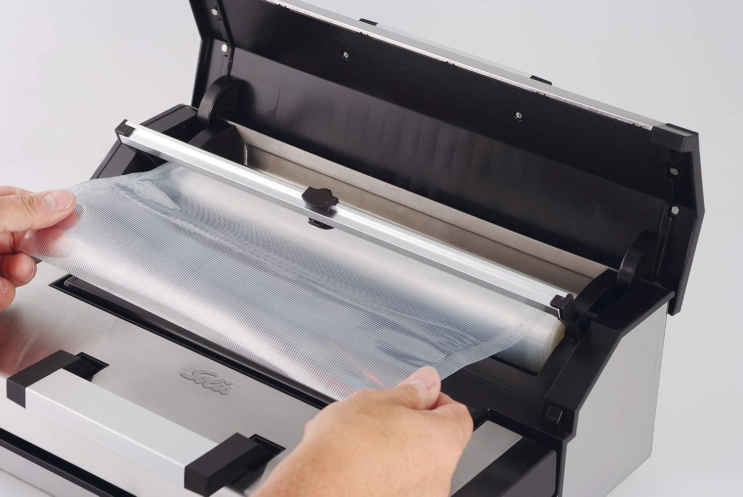 Solis Vac Professional 572 Vacuum Sealer, hands pulling film from roll
