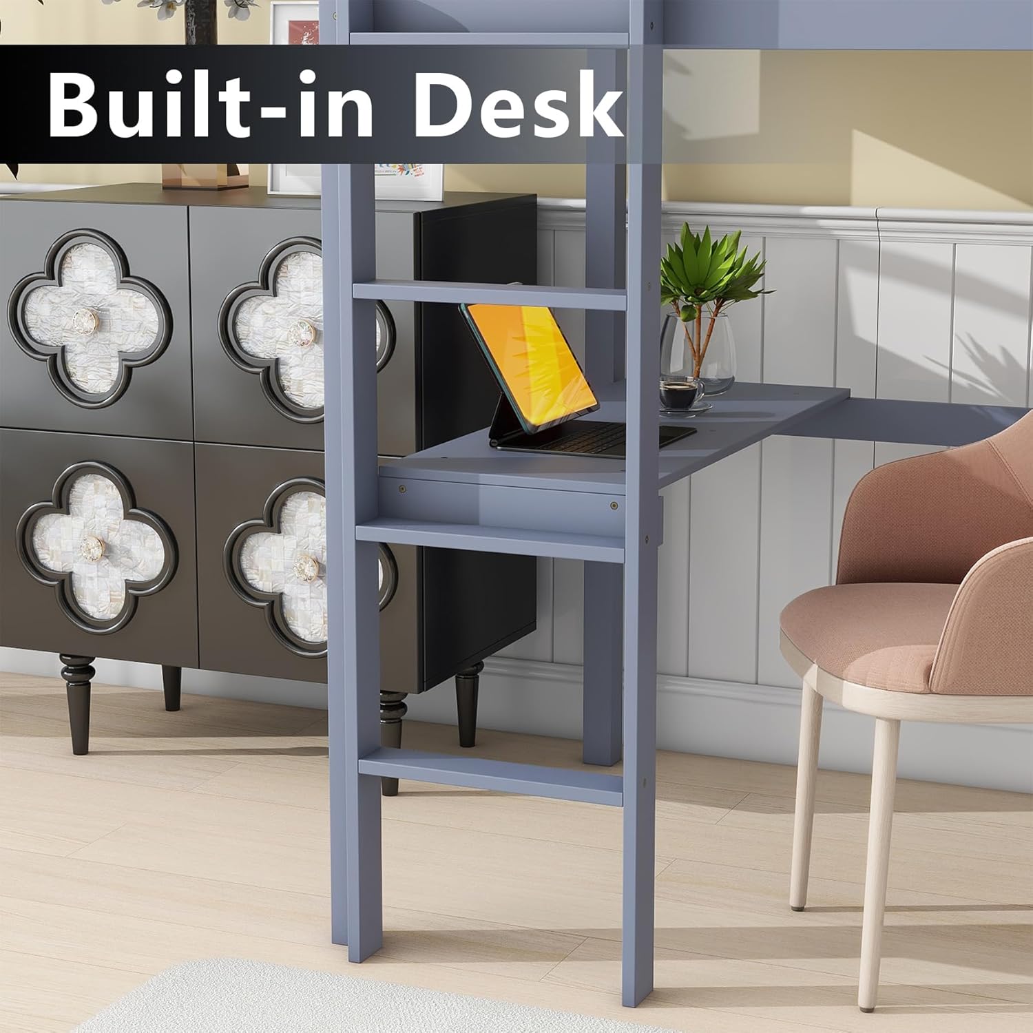Close-up image of the built-in desk of the loft bed, showing a laptop and a small plant.