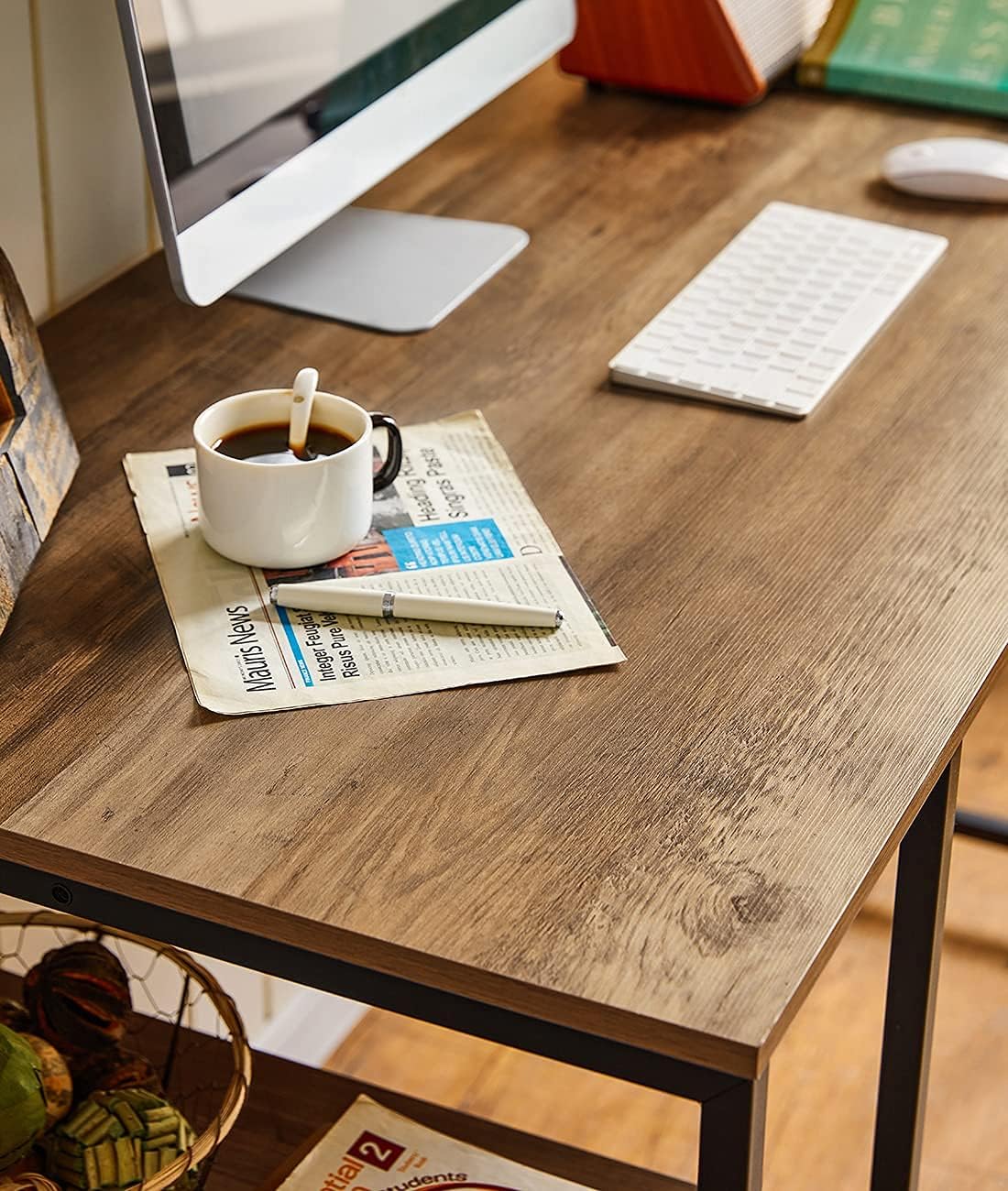 Close-up of the rustic brown engineered wood desk surface with a coffee cup, newspaper, and pen, highlighting its texture and finish.