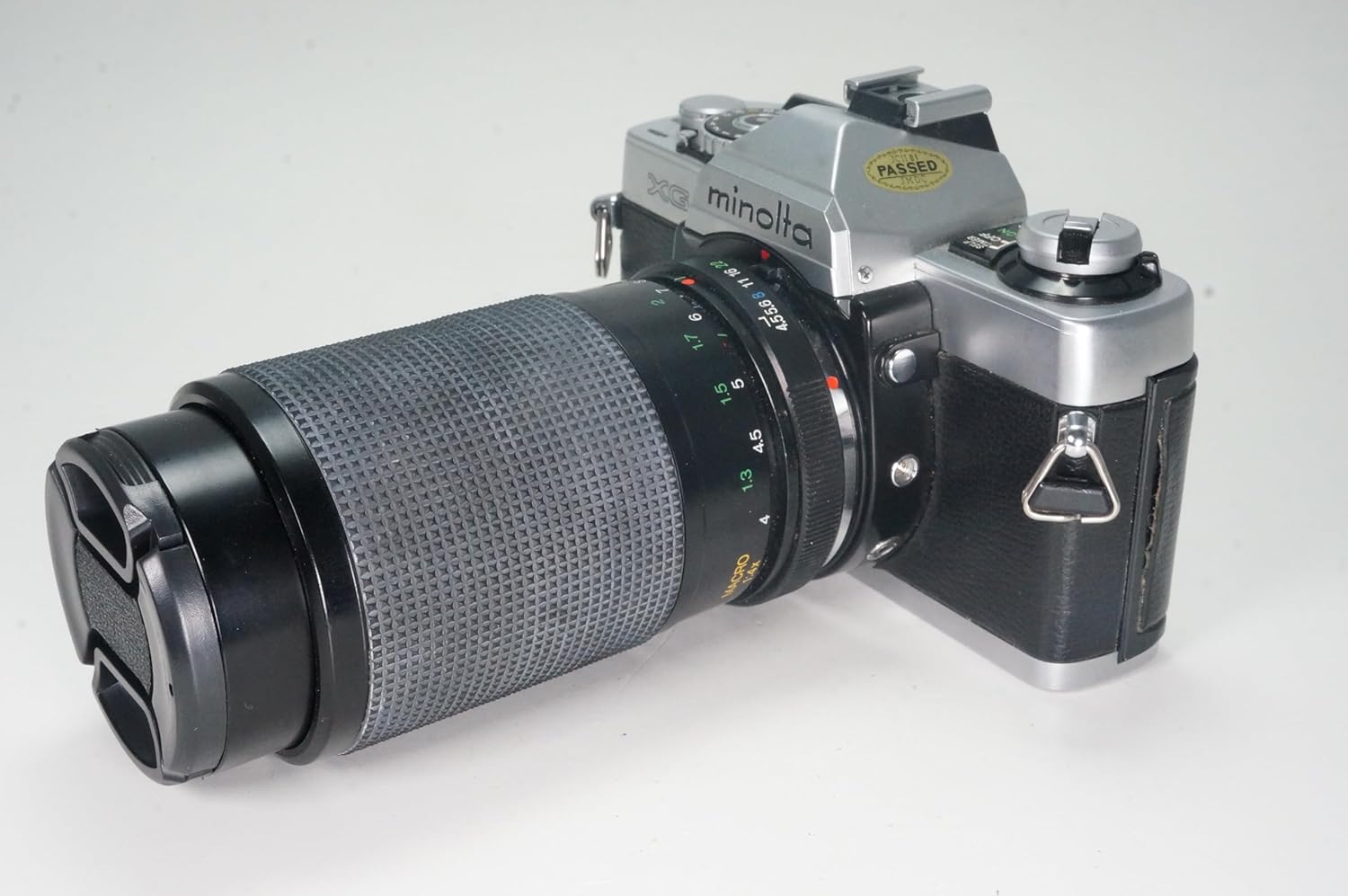 lateral view de la càmera Minolta XG-1 amb objectiu de zoom, que mostra el barril de l'objectiu amb els anells d'enfocament i zoom.