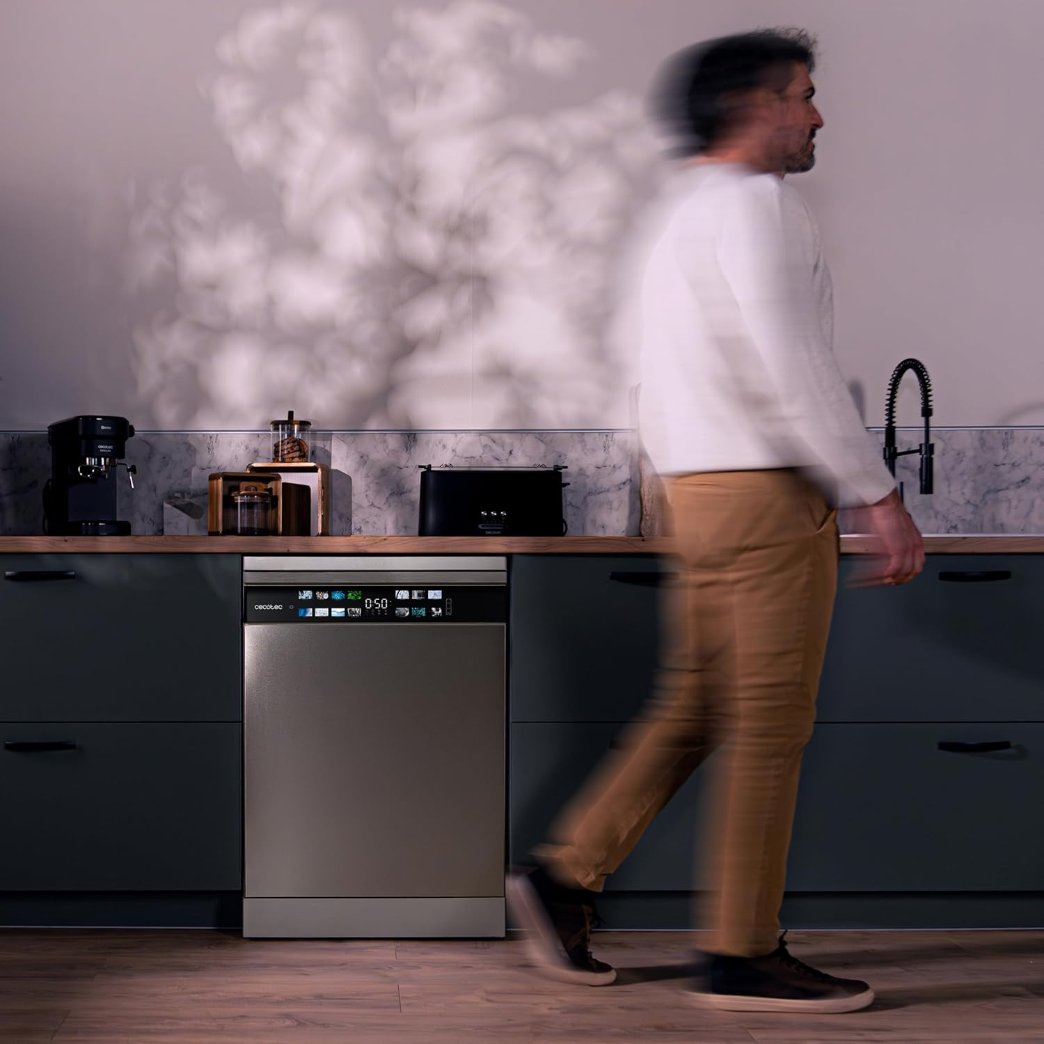 Person walking past a quiet dishwasher in a kitchen