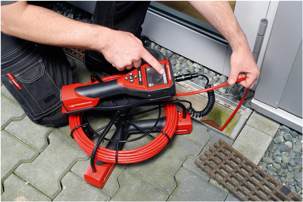 User inserting the ROSCOPE i2000 camera probe into a drain