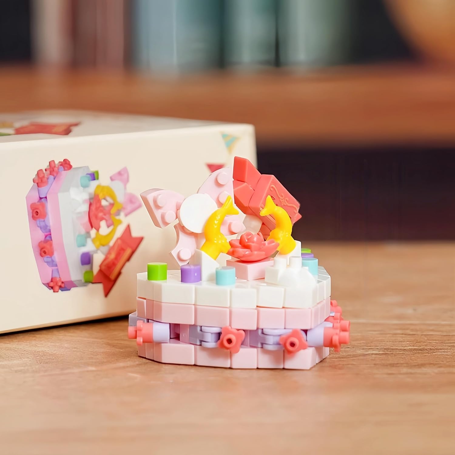 Close-up view of the assembled QMEAKMONY Rose Lychee Mini Building Blocks Cake next to its box.