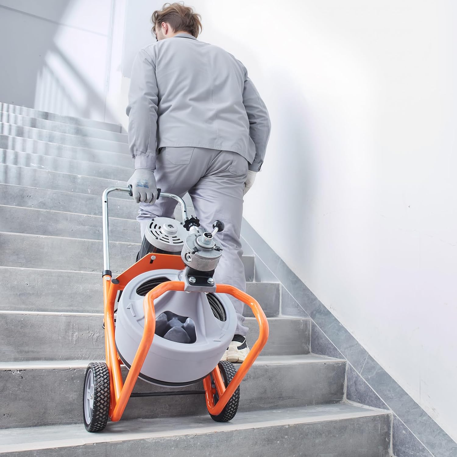 Man operating the VEVOR Drain Cleaner Machine with foot pedal and cable feed lever