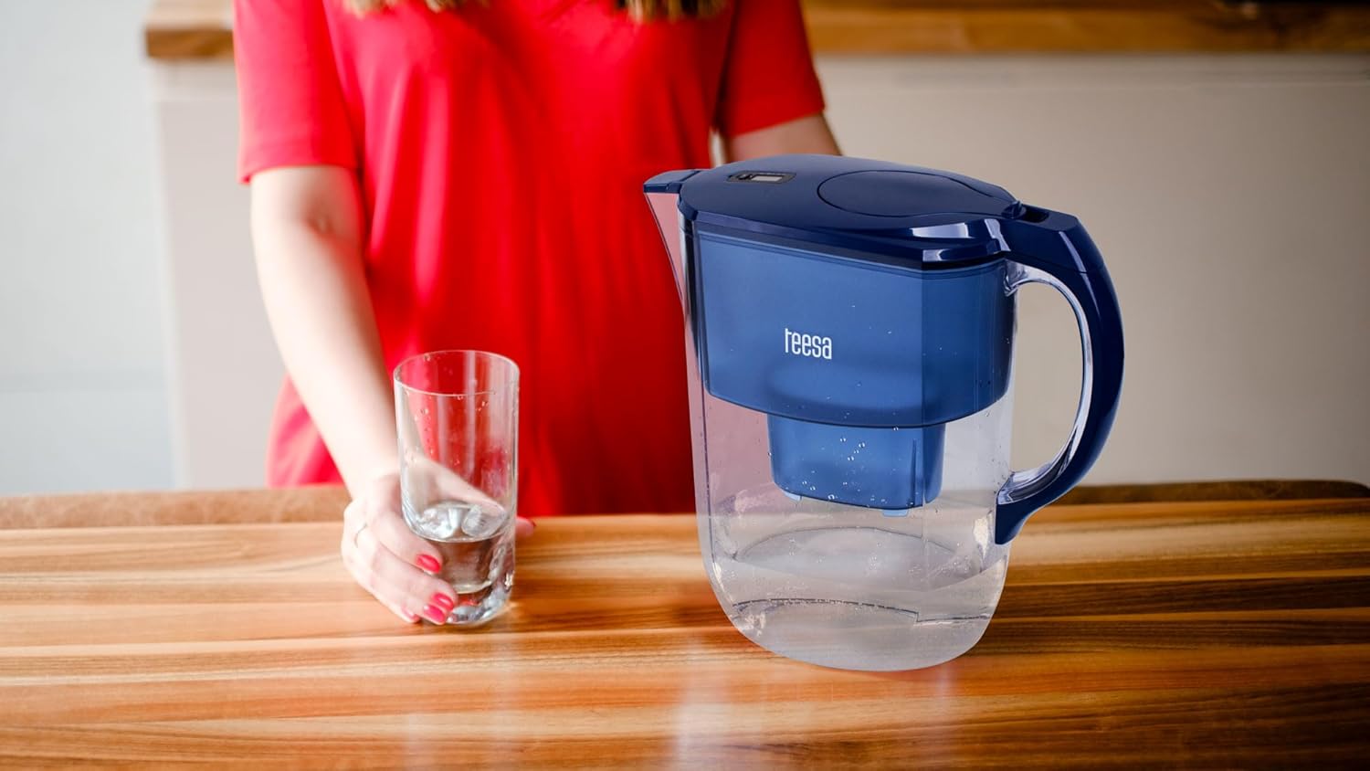 Teesa Water Filter Pitcher in use on a wooden table with a glass of water