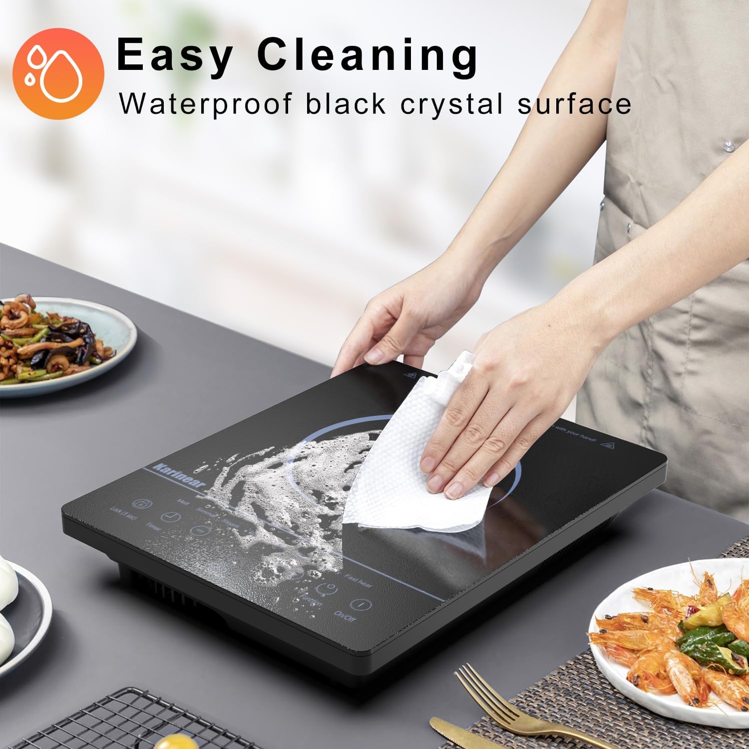 A hand wiping the surface of the Karinear Portable Electric Ceramic Cooktop with a cloth, demonstrating its easy-to-clean feature.