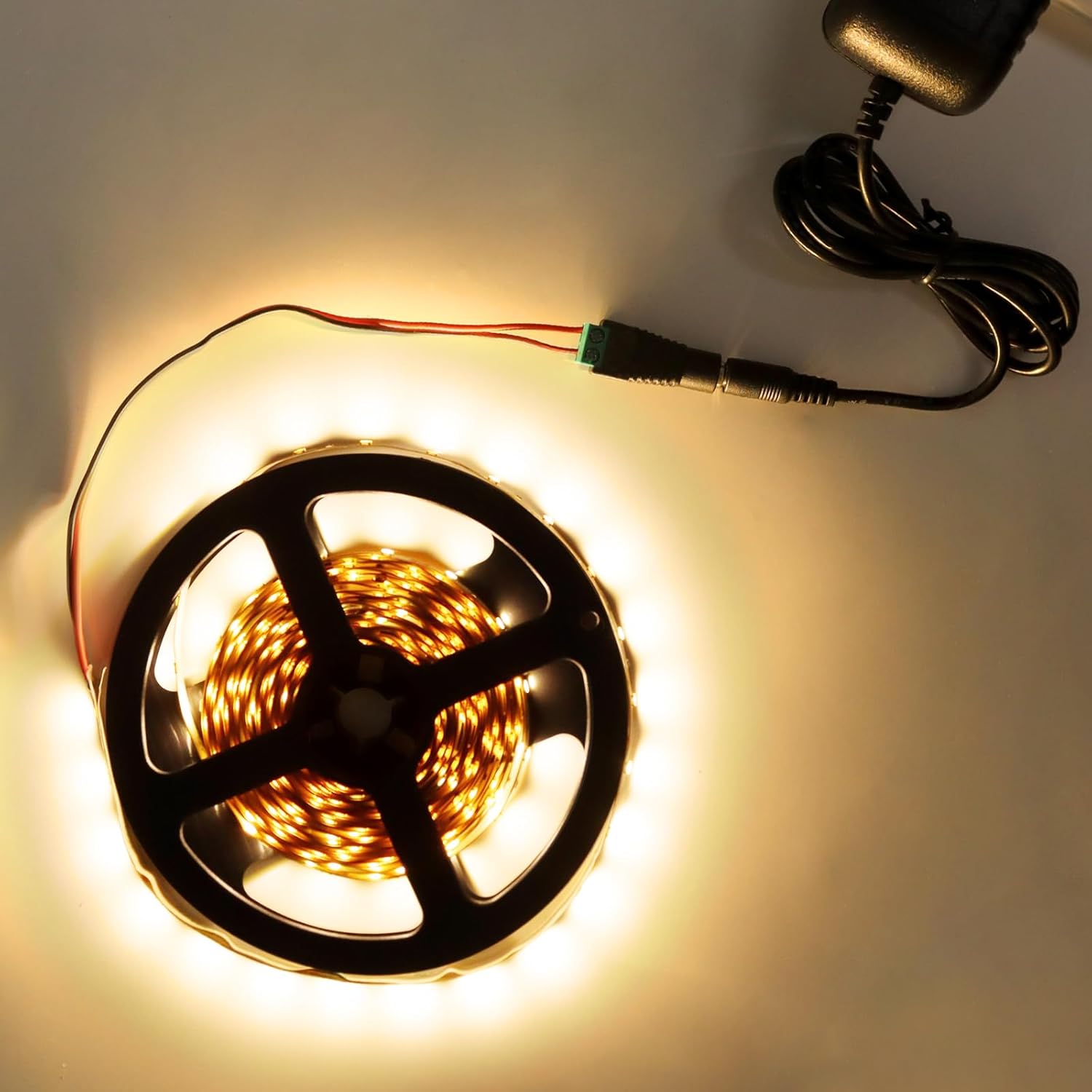 An inShareplus power supply connected to a roll of LED strip lights, demonstrating a typical use case.
