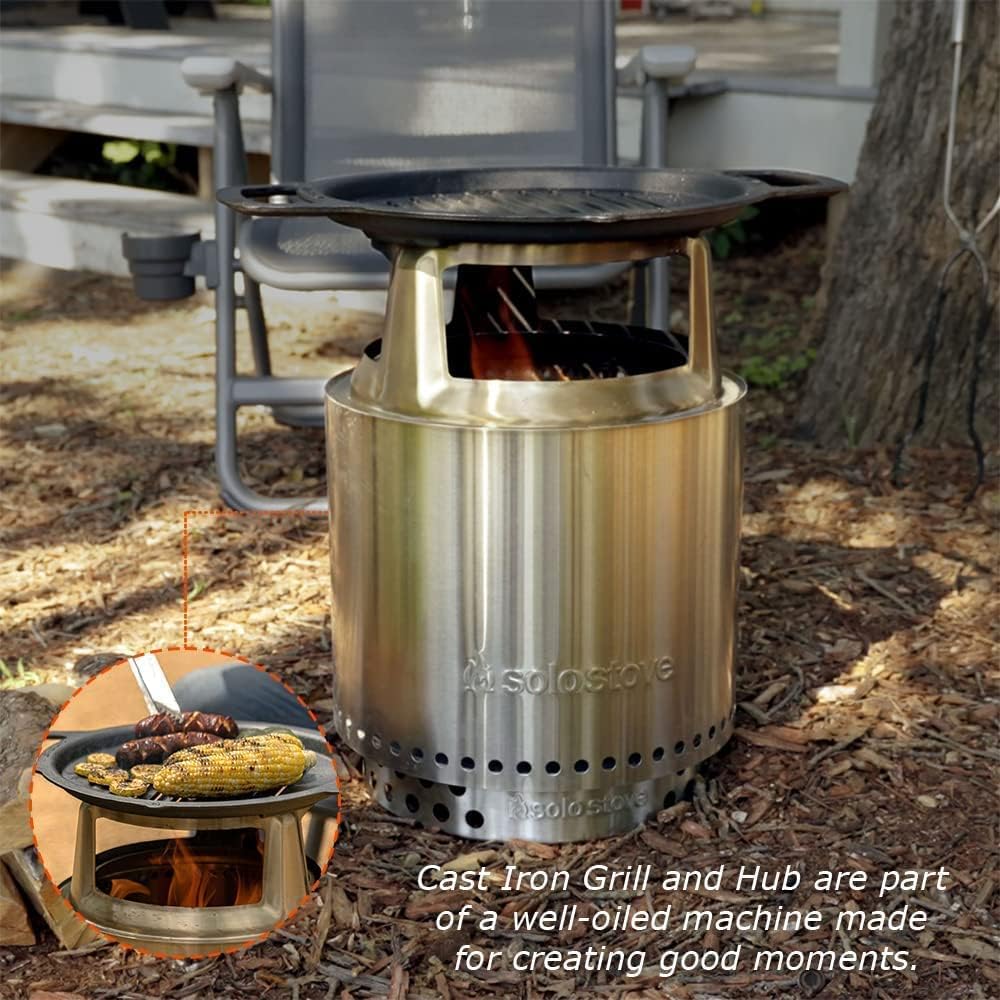 Person cooking burgers and corn on the cob on the Solo Stove Ranger Grill Top