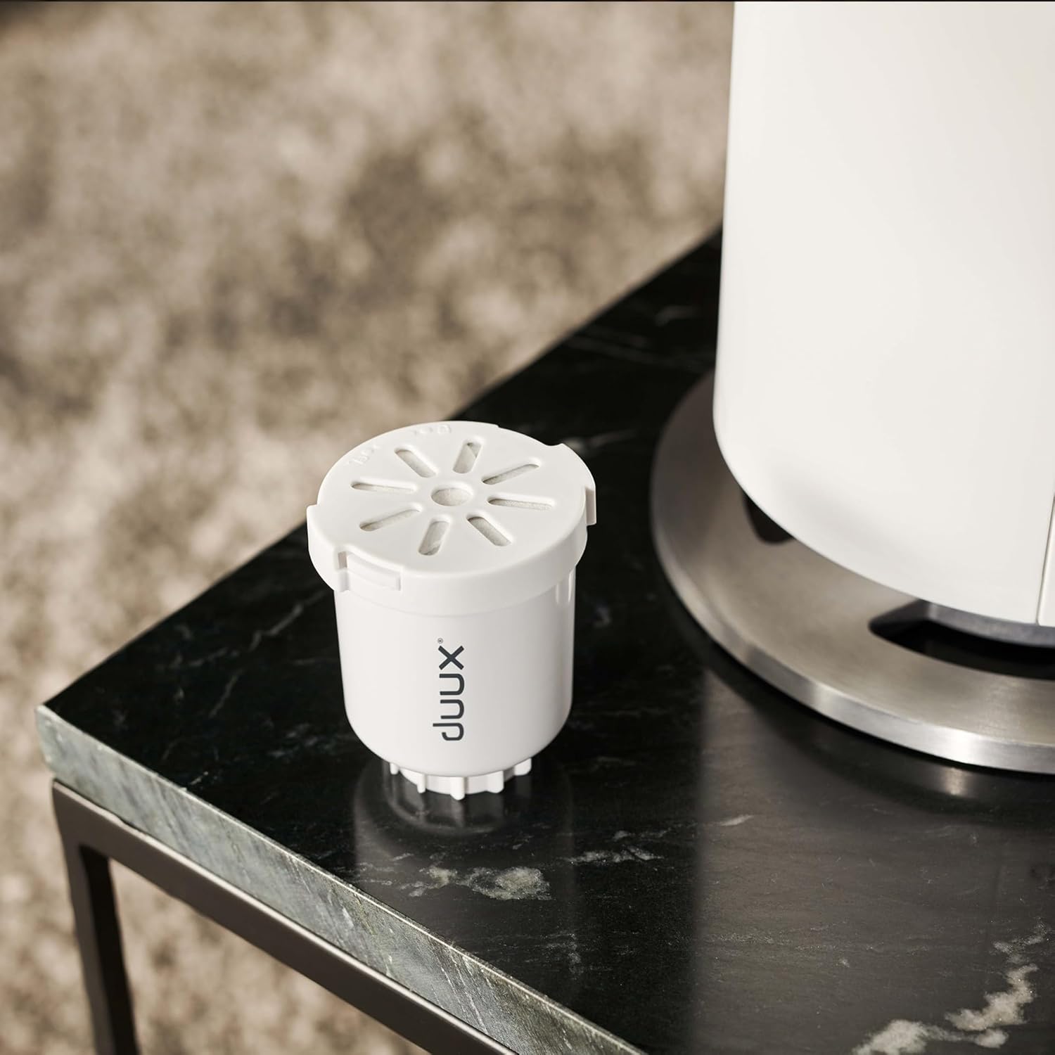 A water filter cartridge for the Duux Beam Mini 2 humidifier placed next to the unit.