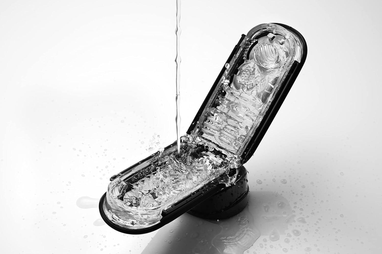 TENGA FLIP 0 (Zero) device being rinsed under running water while open.